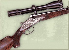 Break open single shot rifle with sidelock, custom engraving and custom carving on stock.